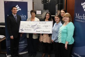 Group photo of a check presentation from Mechanics Cooperative bank.