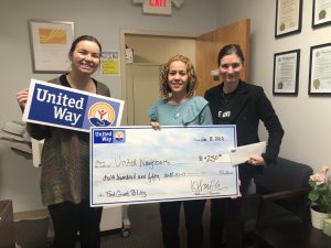 3 women presenting a check for a food pantry in an office