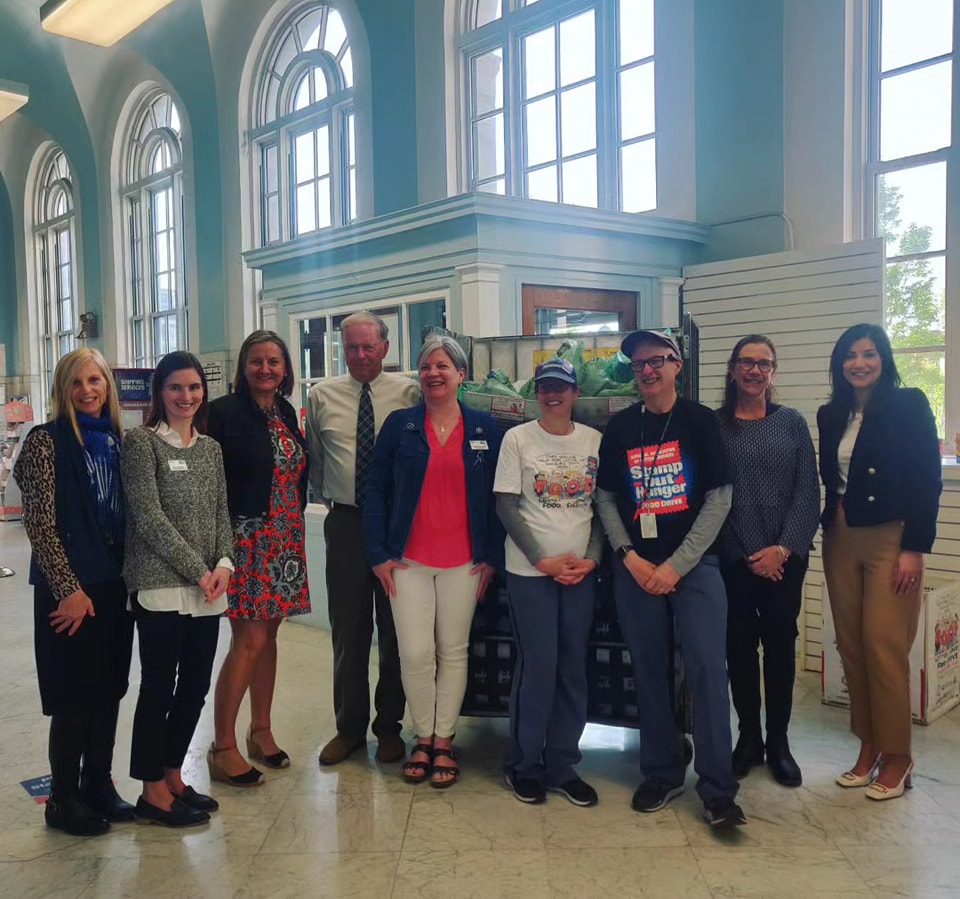 UWGFR Executive Director Kim Smith poses with Mayor Paul Coogan, Stamp Out Hunger sponsors, USPS employees, and UWGFR employees in Fall River Post Office lobby