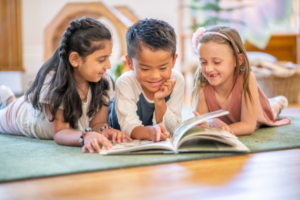 Diverse group of three children reading a book together