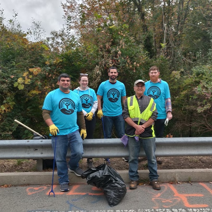 Clean-up volunteers posing in front of guardrail